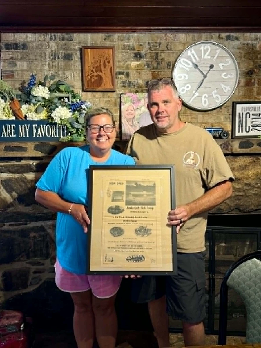 Laura and her husband Derrick Boyd, owners of The Ambered Jack, with a news article about the original Amber Jack
